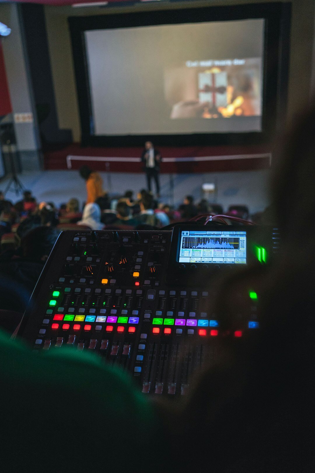 Hands operating a live video switcher panel with camera preview monitors